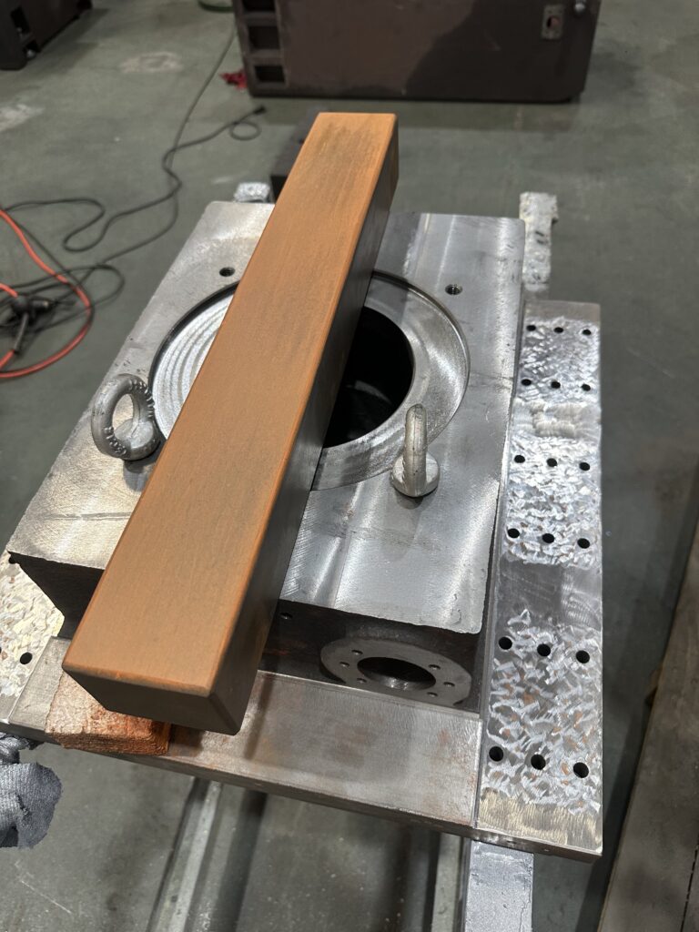 A heavy-duty surface grinder machining construction equipment components. The image shows precision grinding of large hydraulic and structural parts used in excavators, cranes, and loaders, Construction equipment components requiring surface grinding precision machining
