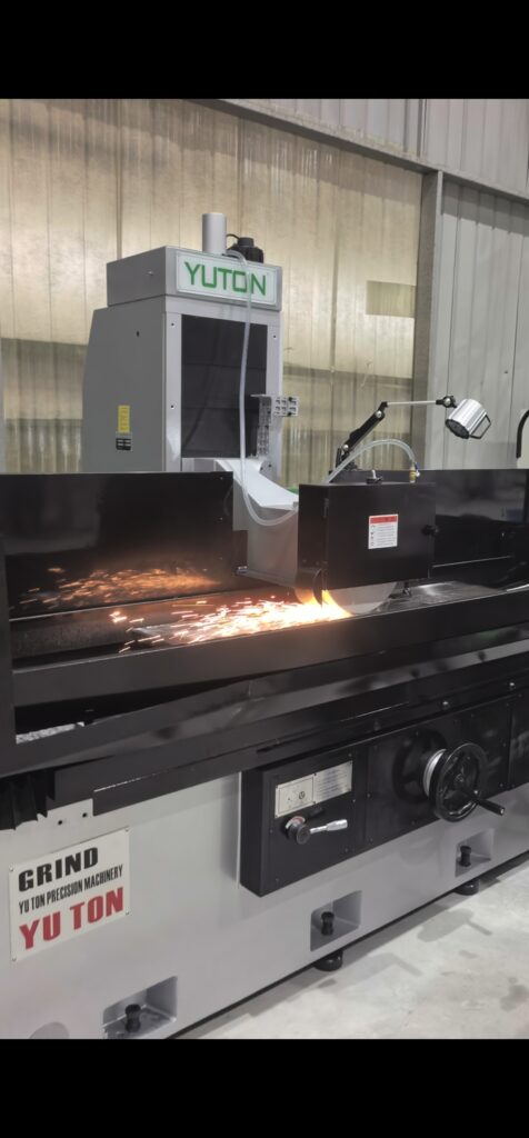 YUTON surface grinder in operation, sparks flying during metal grinding process