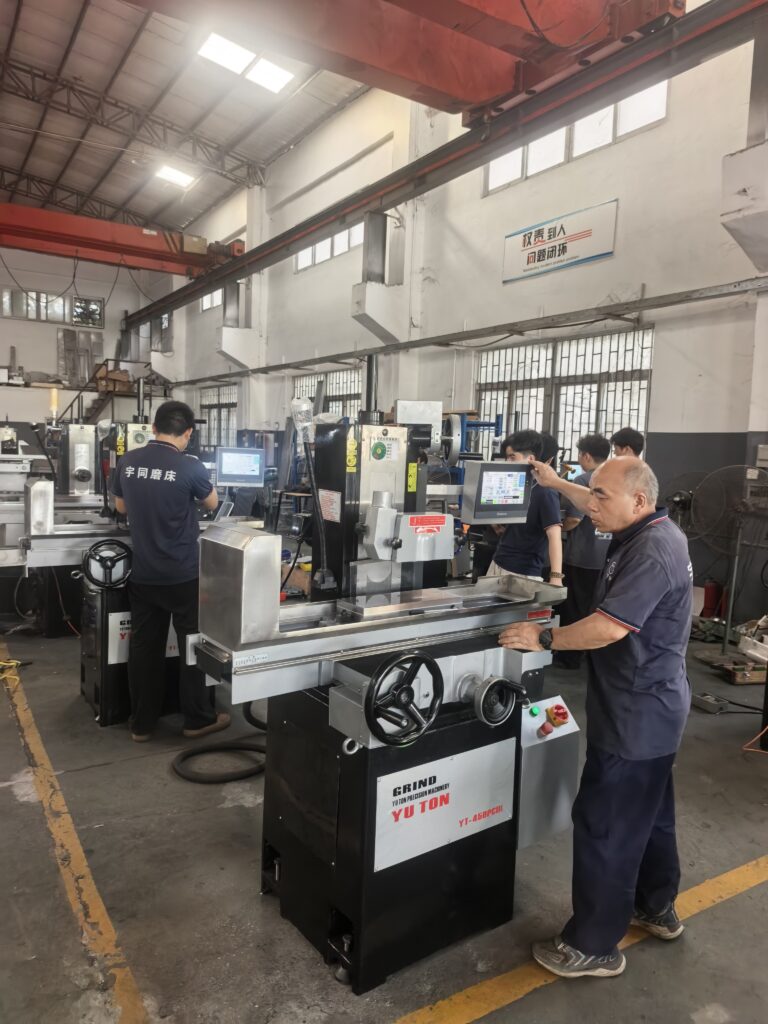 Engineer calibrating YUTON CNC precision grinder in manufacturing facility