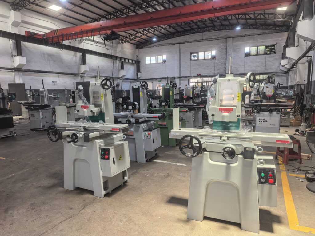 Row of YUTON surface grinders fully assembled and tested in the production workshop, ready for global shipment — featured in the 2026 buying guide.