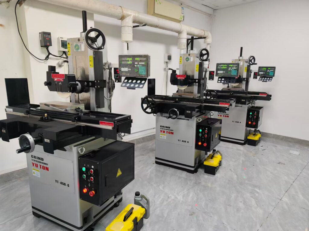 Row of YUTON high-precision surface grinders in a clean production line machining titanium components for medical device manufacturing.