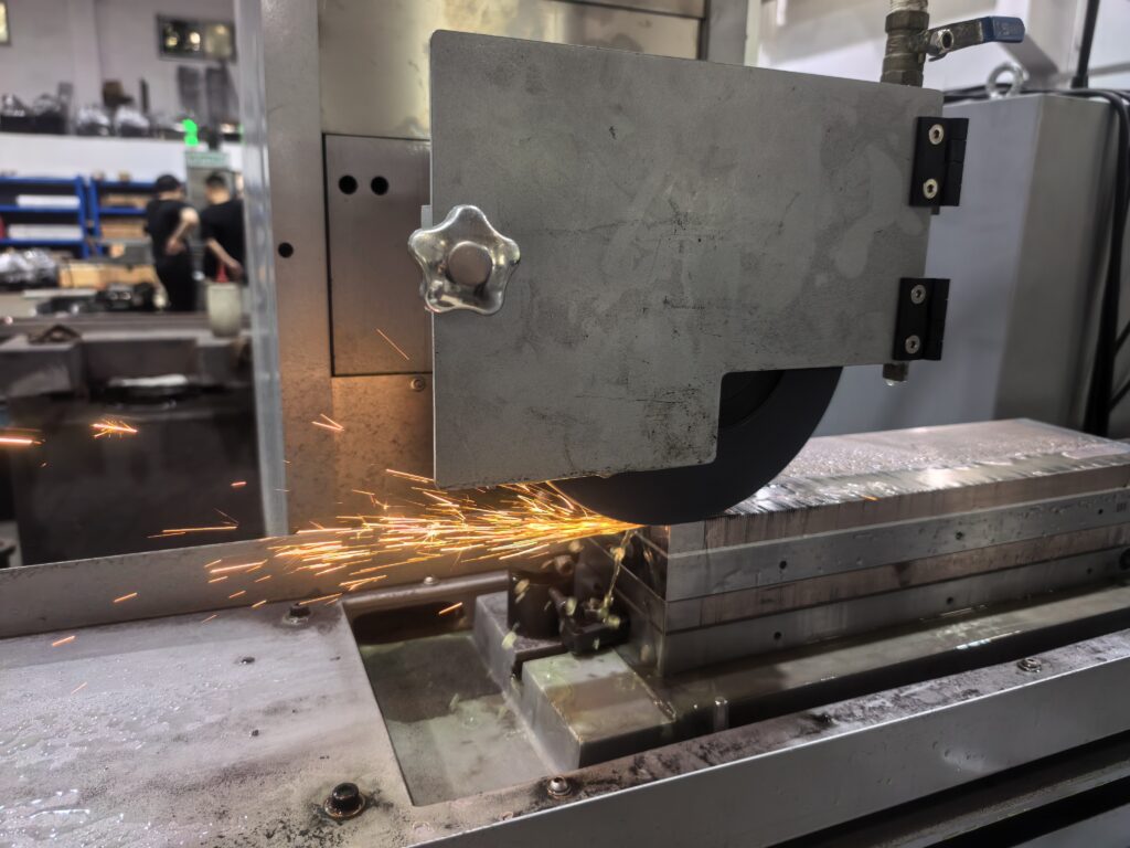 YT-40100CNC CNC surface grinder producing sparks during precision grinding process on hardened steel workpiece
