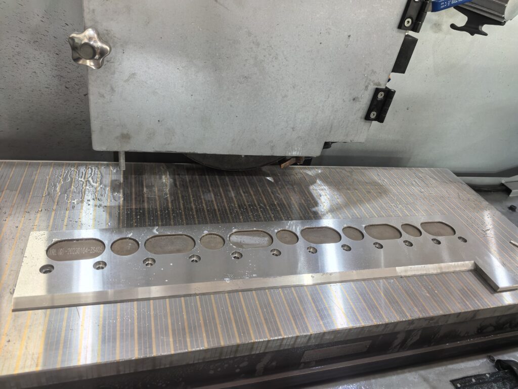 Surface grinder magnetic chuck holding a steel workpiece during precision grinding