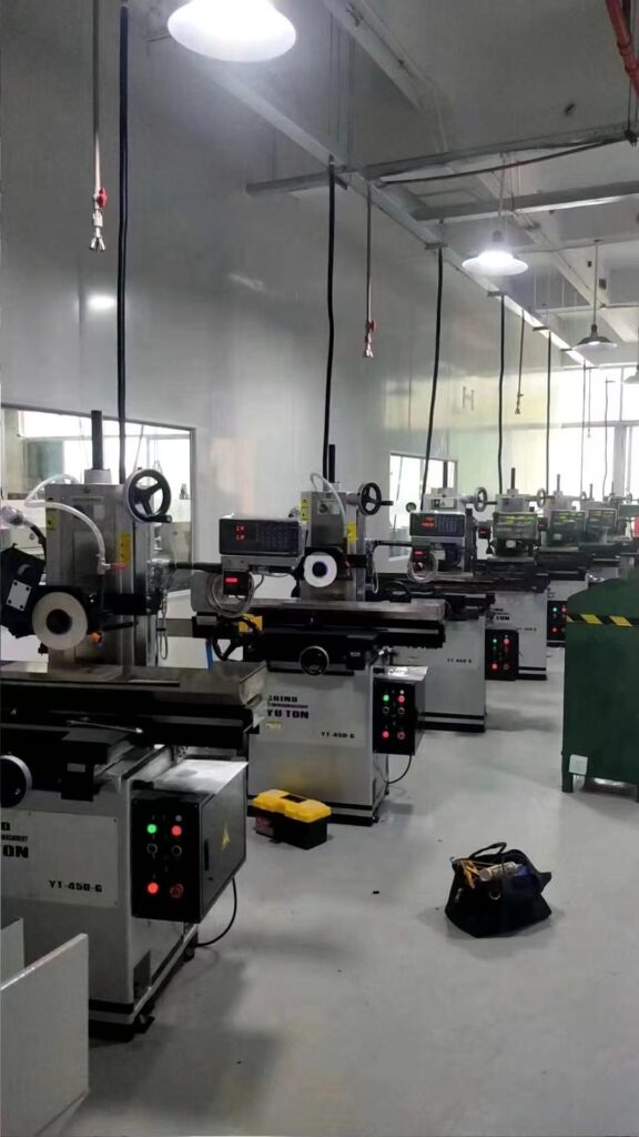 A row of YUTON high-precision surface grinders lined up in a production workshop for automotive parts manufacturing.