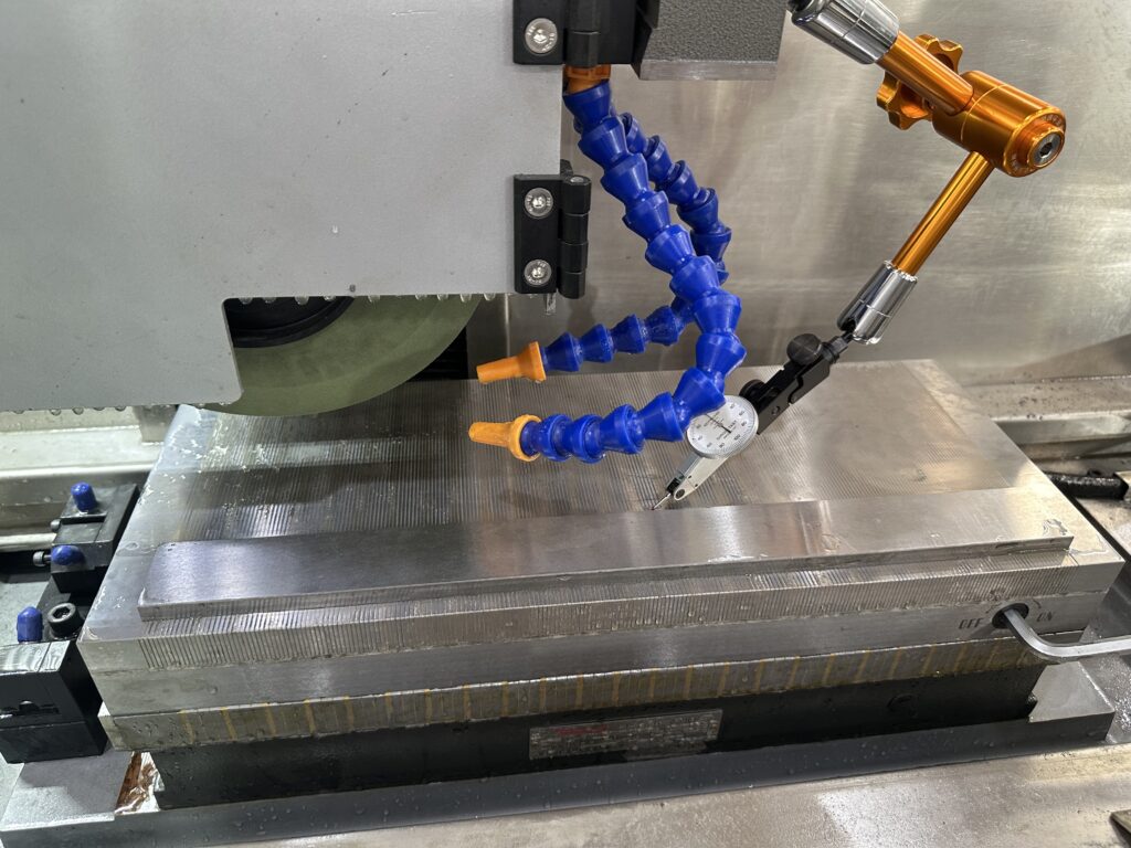 Surface grinder calibration checking magnetic chuck flatness with a dial indicator