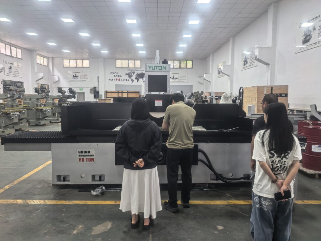 Machine tool distributor demonstrating a surface grinder to an industrial customer